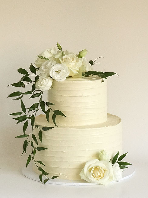 2-tier wedding cake with flowers and greenery